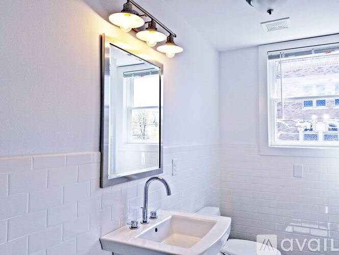 A white bathroom with a sink and mirror.