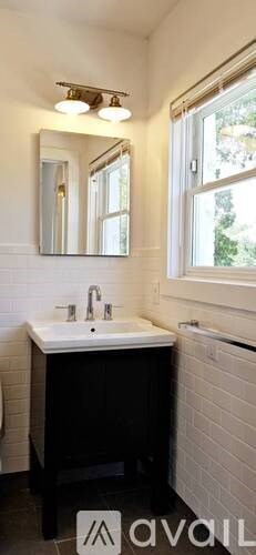 A bathroom with a white sink and a mirror above it.