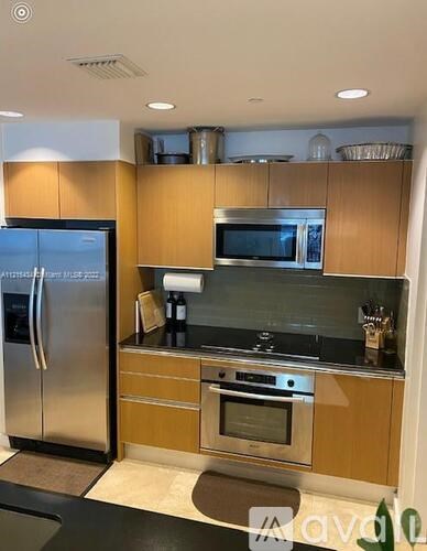 A modern kitchen with wooden cabinets and stainless steel appliances.