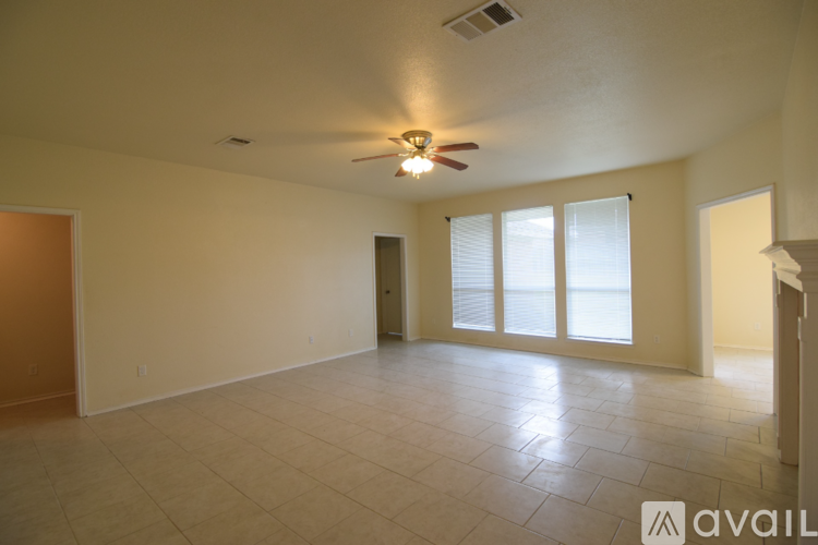 A spacious room with a ceiling fan and sliding glass doors.