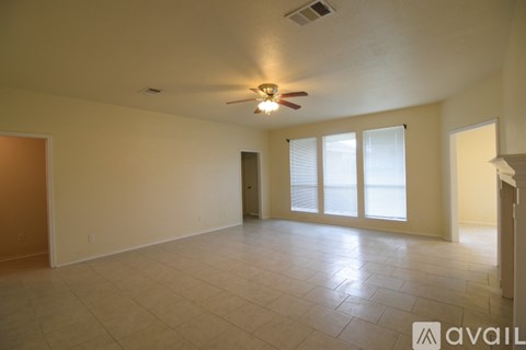 A spacious room with a ceiling fan and sliding glass doors.