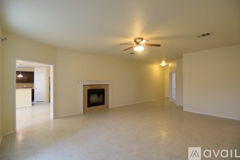A spacious living room with a fireplace and a ceiling fan.