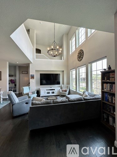 A living room with a grey couch and a television.