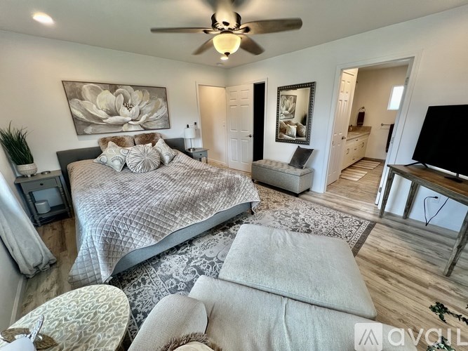 A bedroom with a large bed and a ceiling fan.