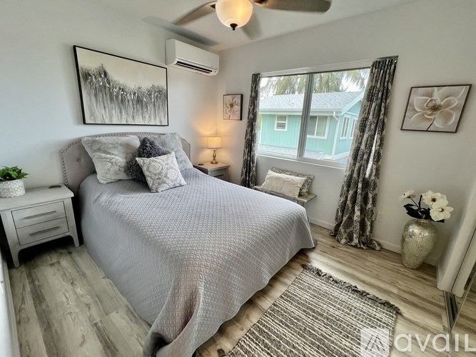 A bedroom with a large bed and a ceiling fan.