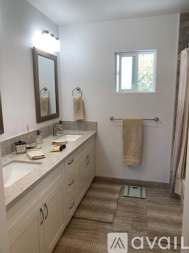 A bathroom with a sink, mirror, and towel rack.