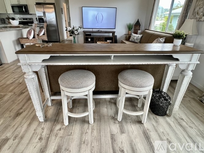 A kitchen with a wooden island and two stools.