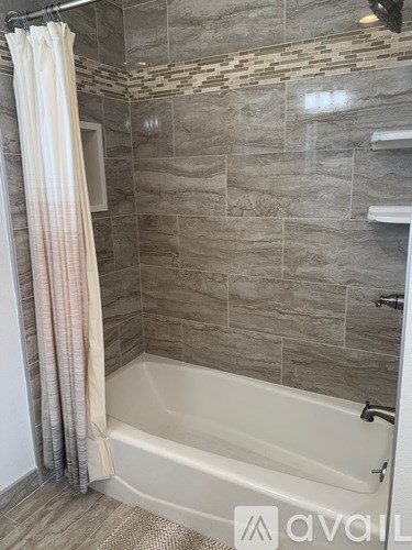 A bathroom with a white tub and a shower curtain.