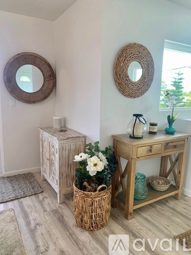 A bathroom with a wooden vanity and a round mirror on the wall.