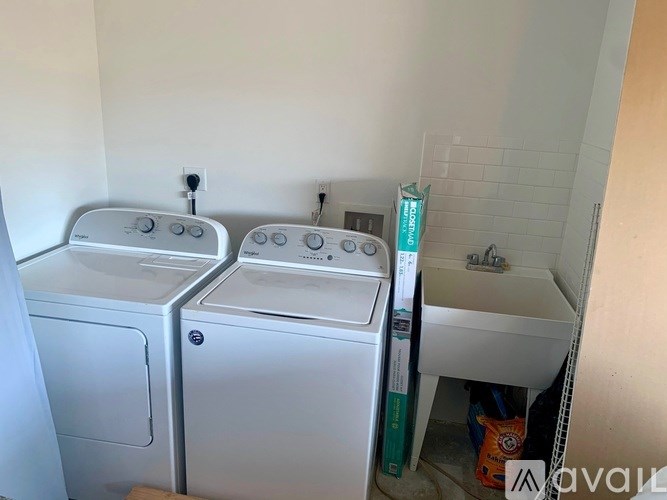 Two front loading washing machines in a small laundry room.
