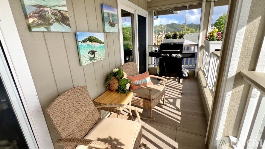 A patio with a table and chairs and pictures on the wall.