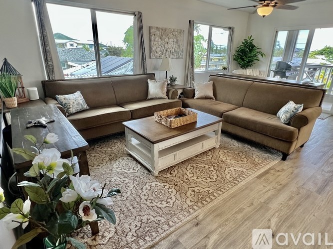 A living room with a brown sofa, a coffee table, and a rug.