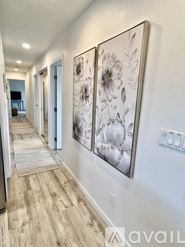 A hallway with two large floral paintings on the wall.