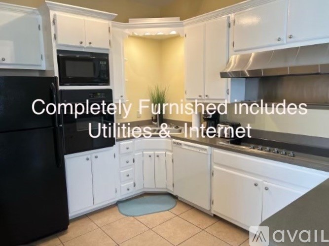 A kitchen with white cabinets and appliances is available for rent.