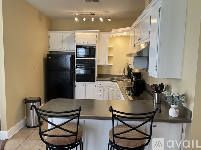A kitchen with black and white appliances and cabinets.