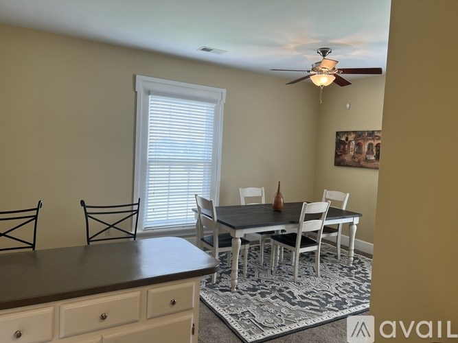 A dining room with a table and chairs.
