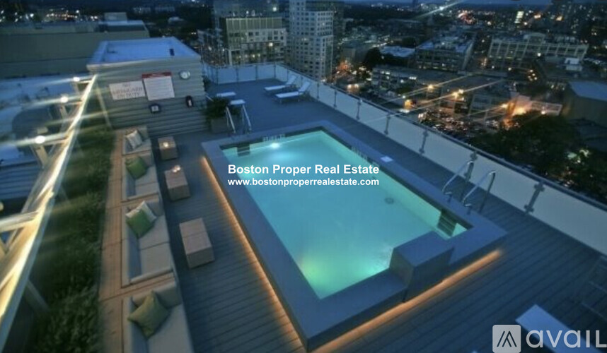 A swimming pool on a rooftop with a cityscape in the background.