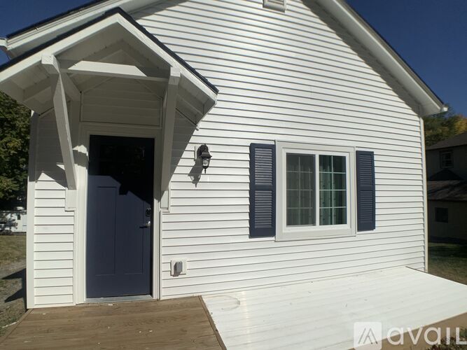 A white house with a blue door and window shutters.