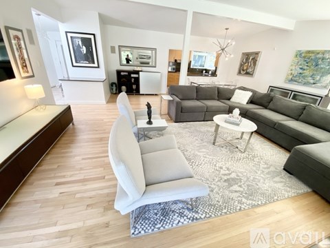 A living room with a grey couch and a white chair.