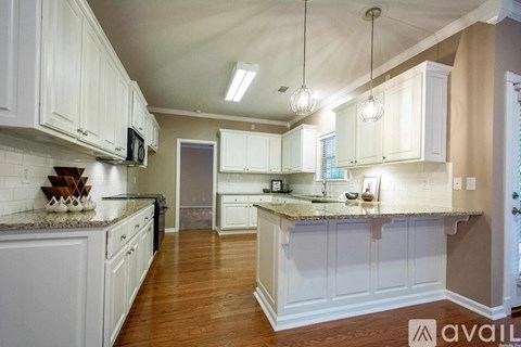 A kitchen with white cabinets and a granite countertop.