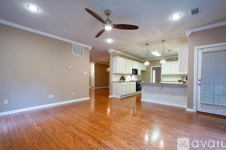 A spacious room with a ceiling fan and wooden flooring.