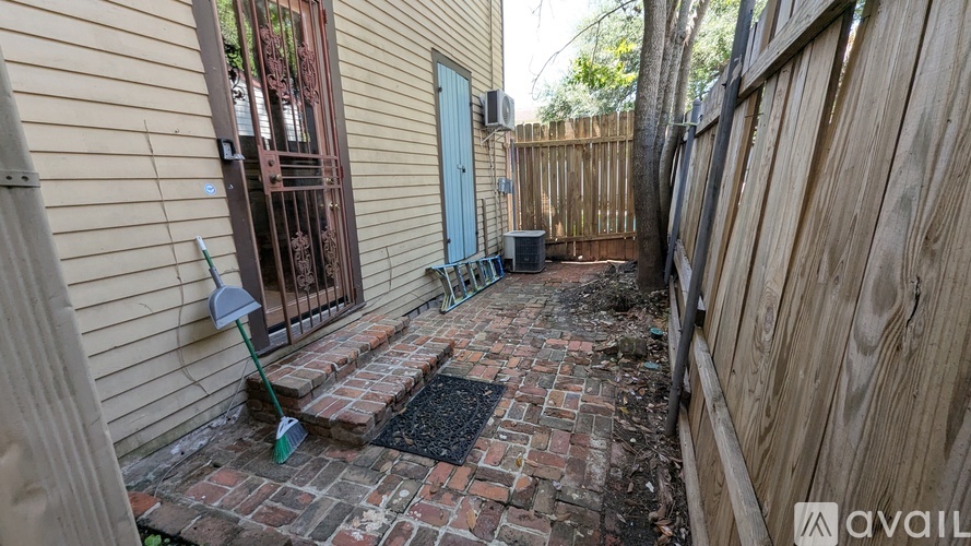 A backyard with a brick patio and a blue door.