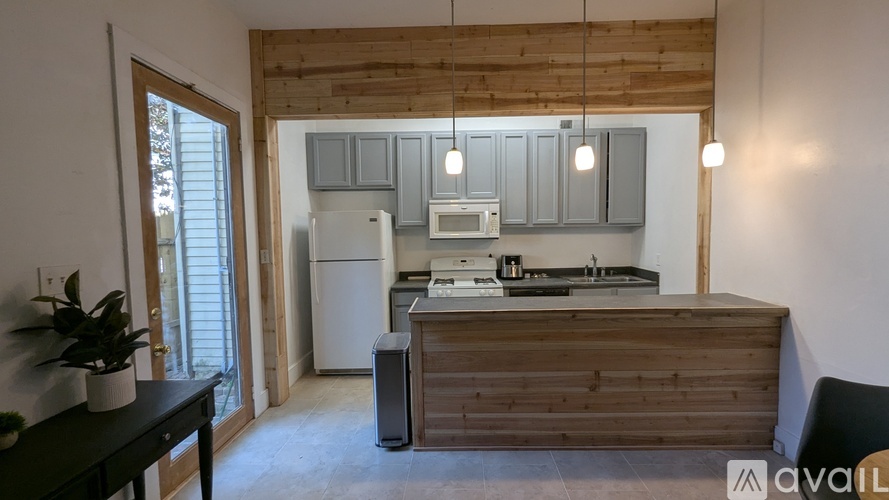 A kitchen with wooden cabinets and a white fridge is shown.