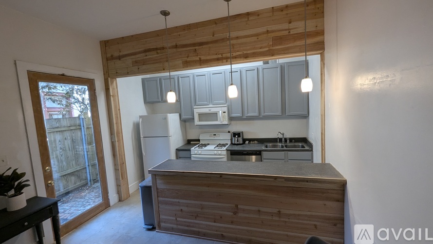 A kitchen with wooden cabinets and a countertop with a sink and a stove.