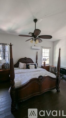 A bedroom with a large bed and a ceiling fan.