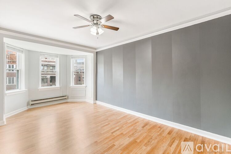 A room with a ceiling fan and wooden flooring.