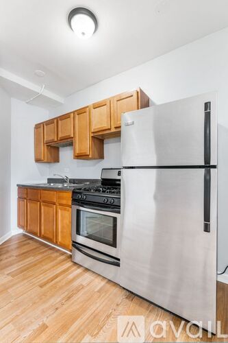 A kitchen with a stainless steel refrigerator, oven, and wooden cabinets.