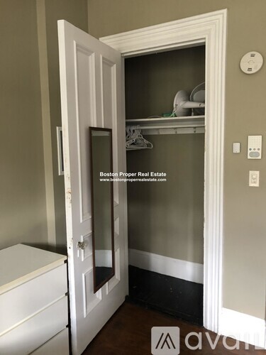 A white door is open to a small closet.