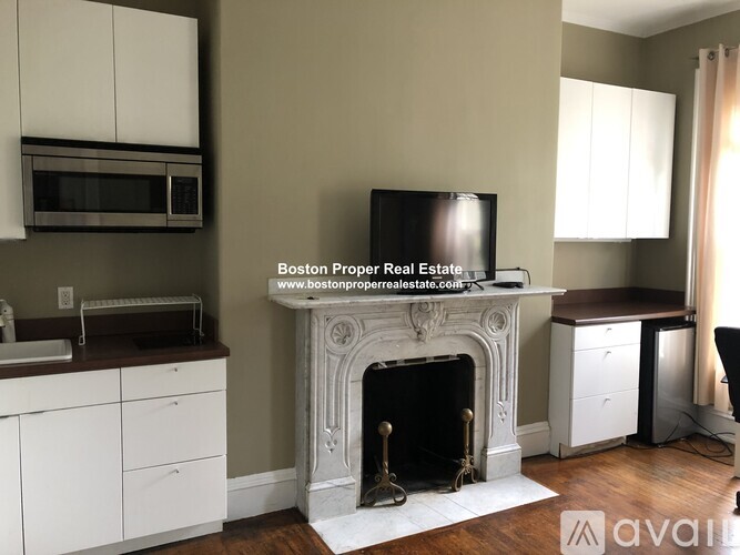 A living room with a fireplace and a television mounted above it.