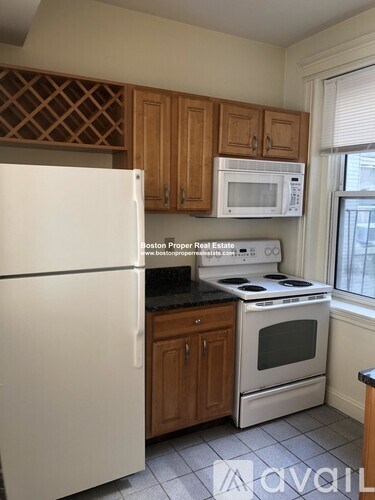 A kitchen with a white refrigerator, white microwave, white stove and white oven.