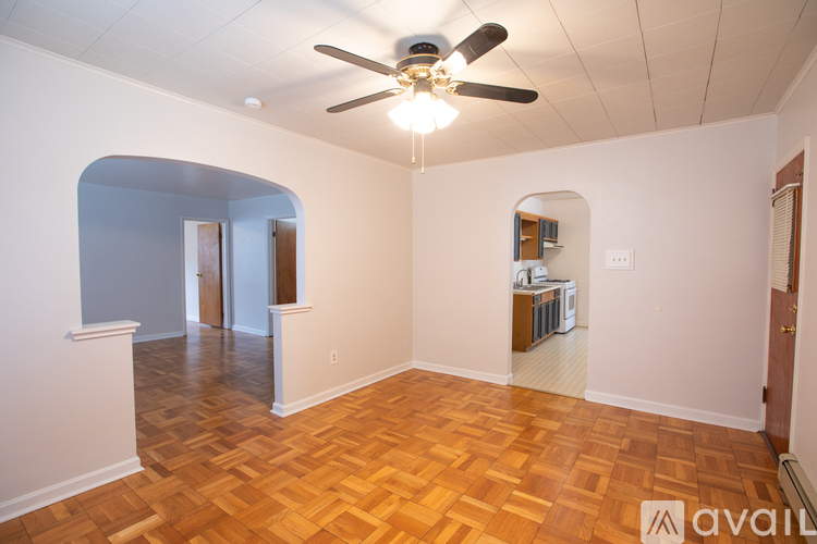 A room with a ceiling fan and wooden flooring.