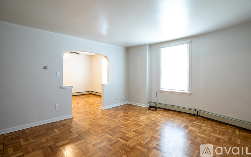 A room with wooden flooring and a window.