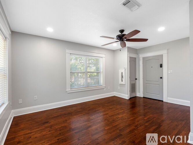 A room with a ceiling fan and wooden flooring.