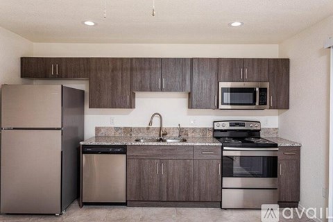 A kitchen with a refrigerator, stove, and microwave.