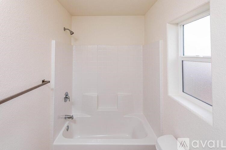 A white bathroom with a tub and a toilet.