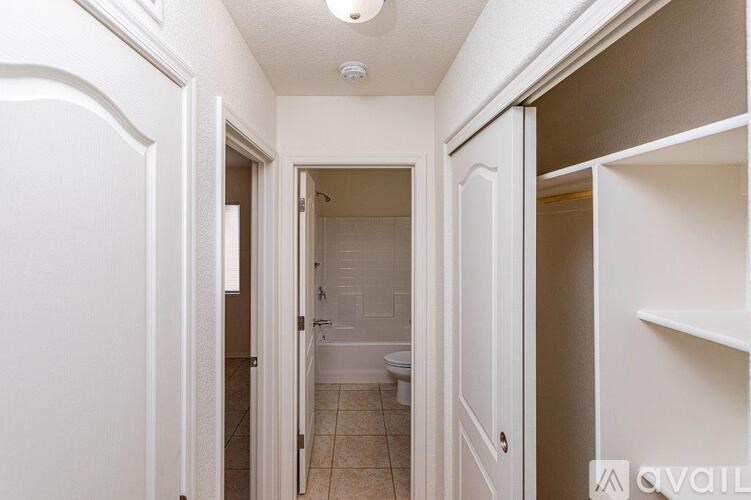 A white hallway with a toilet visible in the distance.