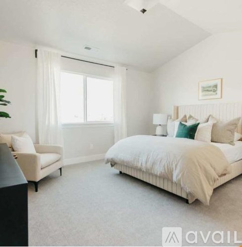 A bedroom with a large bed and a chair.