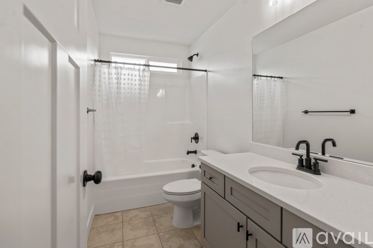 A bathroom with a toilet, sink, and shower.