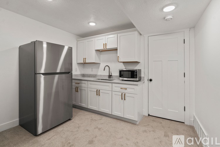A kitchen with white cabinets and a stainless steel refrigerator.