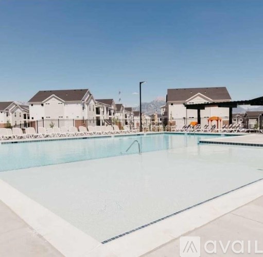 A large swimming pool in front of a row of houses.