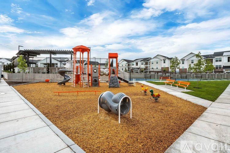 A playground with a slide, swings, and a seesaw.