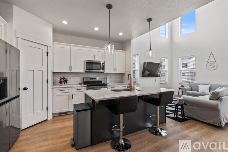 A modern kitchen with a bar stool and a dining table.