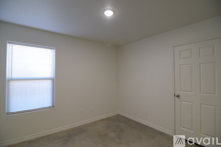 A room with a door, window, and a light on the ceiling.