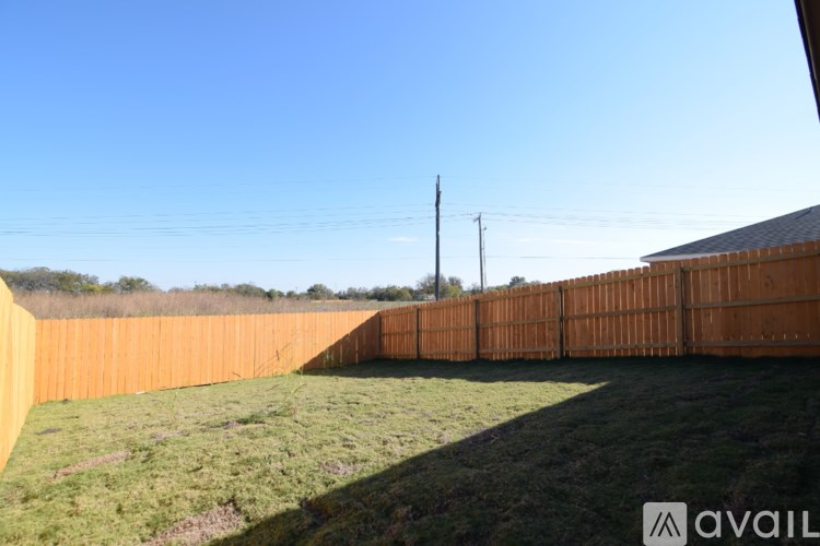 A long wooden fence runs along a grassy field.