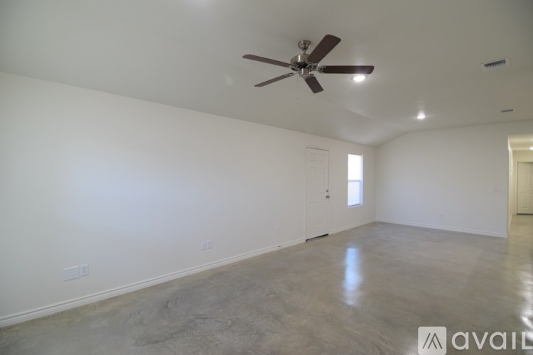 A spacious room with a ceiling fan and lighting fixtures.