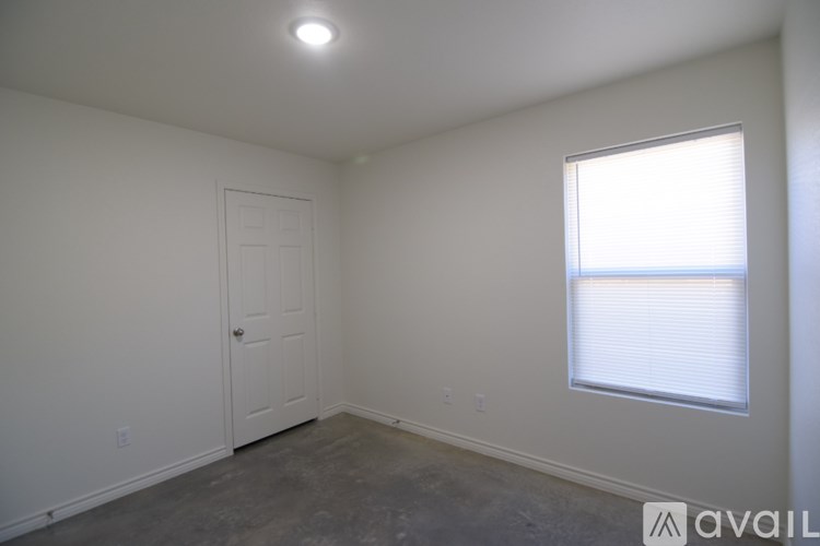 A room with a door, window, and a light on the ceiling.
